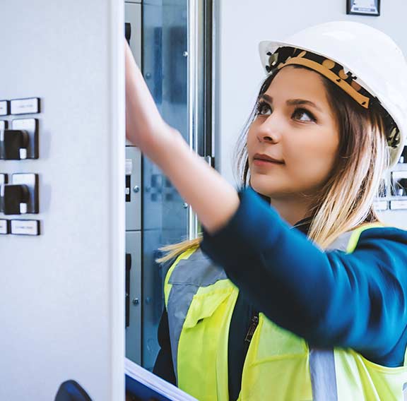 Young female maintenance engineer working at energy control room